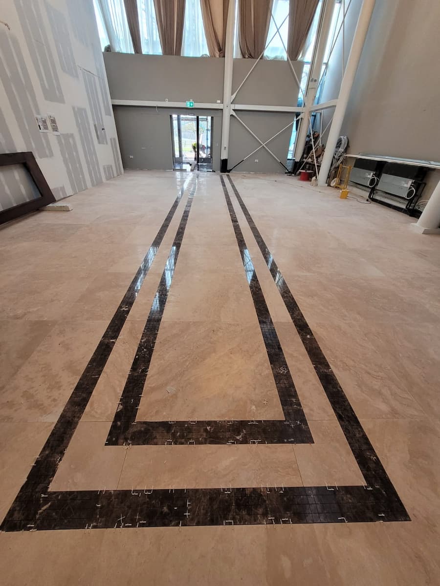 Montaj gresie marmură bej cu model geometric negru pentru pardoseală hol Chișinău